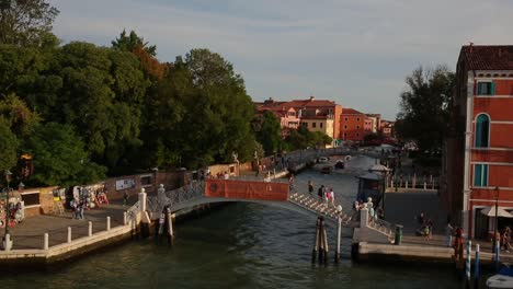 La-Gente-Camina-Sobre-El-Puente-Panorámico-Por-El-Gran-Canal-Al-Atardecer-Romántico,-Venecia,-Italia