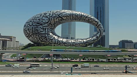 Dubai-traffic-and-the-Dubai-Metro-on-Sheikh-Zayed-Road,-framed-by-the-Museum-of-the-Future-and-the-Emirates-Towers