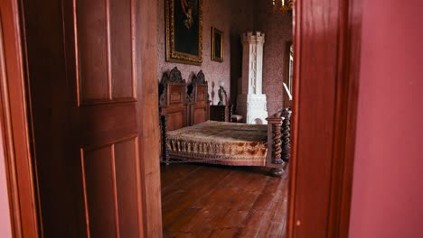 El-Dormitorio-Del-Conde-En-El-Castillo-De-Trakošćan,-Con-Muebles-De-Madera-Ornamentados-Y-Una-Lujosa-Cama-Con-Un-Diseño-Intrincado