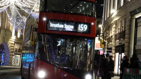 Passengers-catching-a-red-double-decker-bus-during-new-year-festivals,-London,-UK