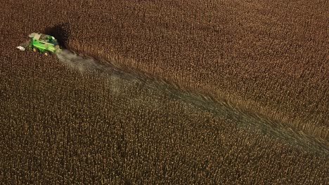 Aerial-drone-shot-of-John-Deere-combine-tractor-harvesting-sunflower-seeds-during-summer-evening-in-Bulgaria