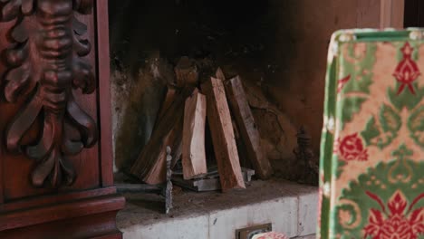 Detailansicht-Eines-Holzkamins-Mit-Gestapelten-Holzscheiten-Und-Einem-Kunstvollen-Holzdekor-Im-Schloss-Trakoscan,-Kroatien