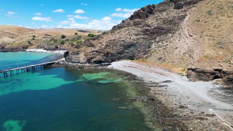 Drohnenaufnahme-Rückwärts,-Um-Einen-Atemberaubenden-Strand-Und-Kristallklares,-Strahlend-Blaues-Wasser-Zu-Offenbaren