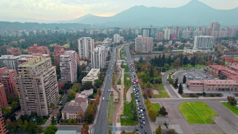 Aerial-cityscape-drone-fly-rush-hour-traffic,-Andean-mountain-Santiago-de-Chile-cityscape,-Escuela-Militar-neighborhood
