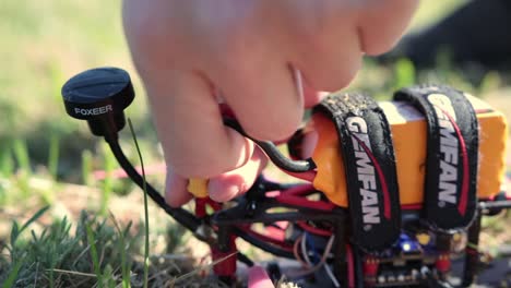 Hands-Pull-Out-Battery-Plug-From-Connector-Of-FPV-Drone-On-Ground-Before-Picking-Up