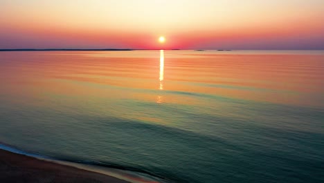 Die-Farben-Des-Sonnenaufgangs-Spiegeln-Sich-In-Den-Meereswellen-Mit-Blick-Auf-Die-Strandhäuser