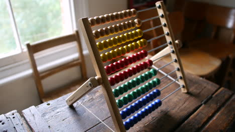 Colorful-wooden-abacus-on-a-rustic-table,-ideal-for-educational-themes,-mathematics,-and-vintage-classroom-settings