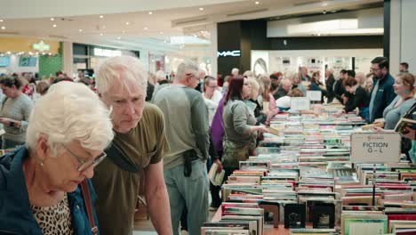 A-large-crowd-of-people-shopping-at-a-library-used-book-sale-inside-a-mall