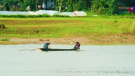 Fisherman-fishing-in-polluted-river-wooden-canoe-boat-in-rural-Bangladesh