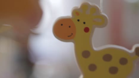 Close-up-of-a-colorful-giraffe-toy-with-a-soft-focus-background,-warm-indoor-lighting