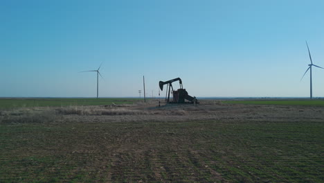 Oklahoma---Oil-Pumpjack-with-Wind-Turbines-in-Background-Wide-Shot