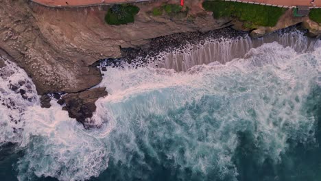 La-Jolla-Cove-Drone-Alto-ángulo-De-Vuelo-De-Arriba-Hacia-Abajo-Sobre-Un-Acantilado-Rocoso-Haciendo-La-Transición-Al-Entorno-Del-Parque