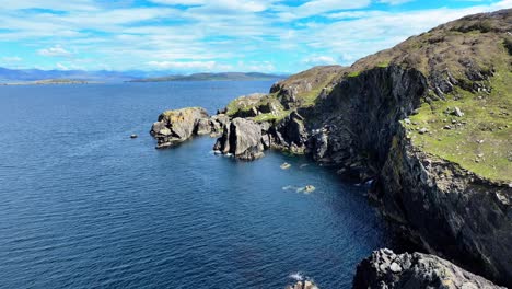 Drohne-Fliegt-Entlang-Der-Felsigen-Küste,-Ruhiges-Blaues-Meer,-Sommertag,-Cods-Head,-West-Cork,-Irland,-Wild-Atlantic-Way