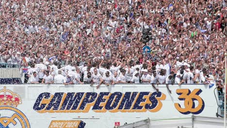Real-Madrid-soccer-players-riding-on-a-bus-celebrate-winning-the-36th-Spanish-soccer-league-title,-the-La-Liga-trophy,-at-Cibeles-Square,-where-thousands-of-fans-in-Madrid,-Spain
