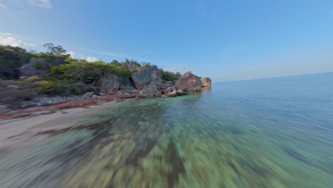 Dynamic-fpv-aerial-along-exotic-Caribbean-sand-beach-and-through-rocky-coast