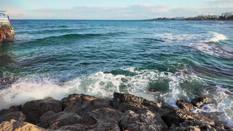 Waves-hitting-rocky-coast-with-clear-water