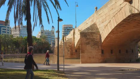 People-walking-under-the-Puente-del-mar-bridge-at-the-Turia-Gardens