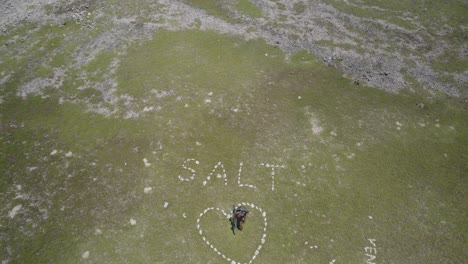 Un-Kiter-Con-Una-Tabla-Celebrando-Dentro-De-Una-Formación-De-Sal-En-Forma-De-Corazón,-Vista-Aérea