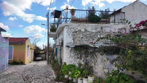 Encantadora-Calle-Estrecha-En-Lefkara-Con-Casas-De-Piedra,-Plantas-En-Macetas-Y-Un-Coche-Rojo.