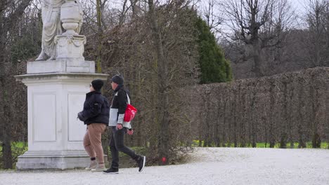 Warmly-dressed-couple-strolling-through-Schonbrunn-Palace-Park