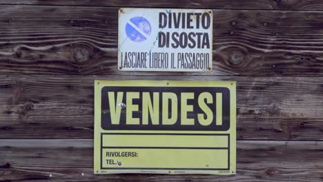 Acercándonos-A-Un-Cartel-Italiano-De-Venta-Y-Un-Cartel-Italiano-De-Prohibido-Estacionar-Fijado-En-Viejas-Tablas-De-Madera-Rústicas