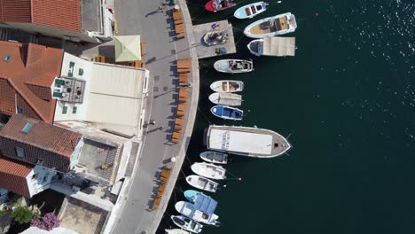 Moored-Boats-perfectly-aligned-alongside-Harbor-Quays-of-Milna-Town,-Croatia,-Drone-Top-down