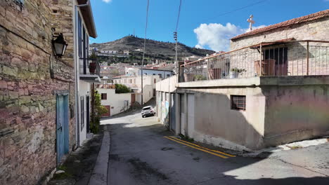 Narrow-street-in-Lefkara-with-stone-houses-and-a-hill-in-the-background
