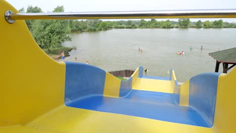 Blick-Von-Der-Wasserrutsche-Auf-Leute,-Die-Im-See-Im-Stadtpark-Schwimmen