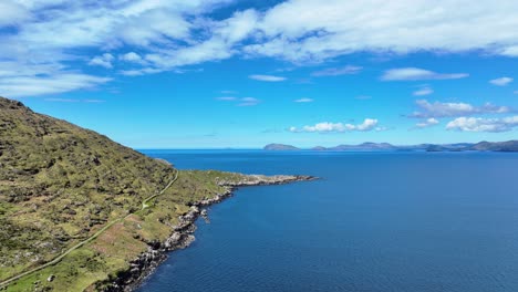 Paisaje-De-Drones-Carretera-Costera-En-Cabeza-De-Bacalao-Con-Las-Montañas-En-El-Anillo-De-Kerry-A-Través-De-La-Bahía-Camino-Atlántico-Salvaje-En-Irlanda