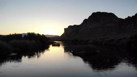 Abends-Bei-Sonnenuntergang-Flussaufwärts-Am-Slat-River-In-Arizona-Mit-Der-Wunderschönen-Silhouette-Der-Vier-Gipfel-In-Der-Ferne