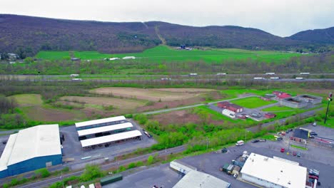 Elevated-view-of-semi-trucks-transporting-goods-on-a-highway-through-green-rural-areas-in-PA