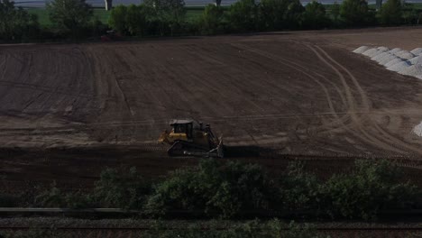 Bulldozer-Moviendo-Tierra-Creando-La-Base-De-La-Carretera-Aérea-Siguiendo-La-Vista-En-El-Sitio-De-Construcción-Del-Amanecer-Temprano-En-La-Mañana