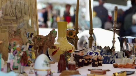 Colorful-flea-market-stall-with-assorted-vintage-objects-and-collectibles,-Cours-Saleya,-Nice,-France,-shallow-focus