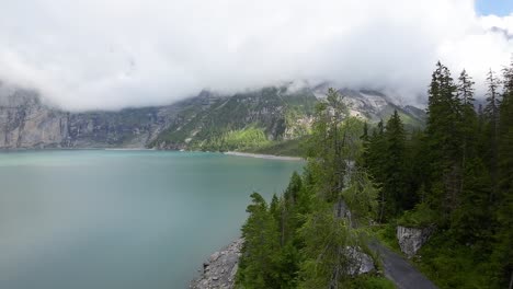 Drone-flight-towards-mountain-Landscape,-aerial-shot-over-a-blue-Oeschinen-lake,-Switzerland,-Europe