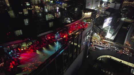 Night-view-of-vibrant-rooftop-party-on-a-high-rise-in-bustling-Bangkok-city,-Thailand
