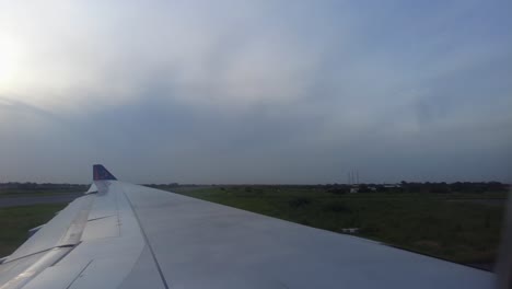 Through-aircraft-window-view-of-SN-Brussels-airplane-landing-and-taxiing-at-Banjul-international-airport-at-sunset