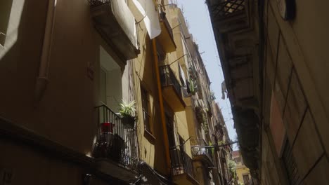 Scenic-small-street-with-tall-apartment-buildings-in-Barcelona-city,-Spain