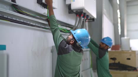 Pakistanische-Arbeiter-Reparieren-Den-Solarwechselrichter-In-Der-Textilindustrie