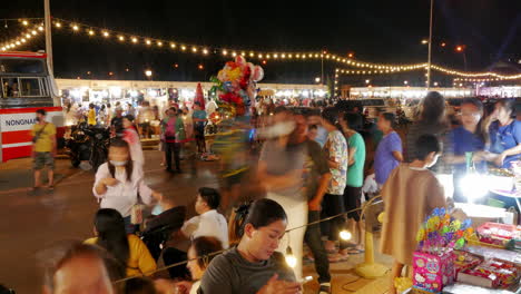 Timelapse-of-a-market-full-of-people-and-vendors,-buying-and-selling-goods-at-a-night-market-in-Chachoengsao,-Thailand