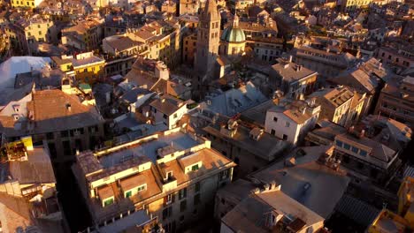 Genoa's-historical-center-at-sunset,-showcasing-old-rooftops-and-narrow-streets,-aerial-view