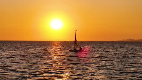Kleines-Schlauchboot-Segeln-über-Einen-Wunderschönen-Sonnenuntergang-Horizont