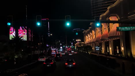 Driving-on-Las-Vegas-Strip-at-Night,-Cars,-Traffic-Lights-and-Illumination-on-Buildings,-Nevada-USA