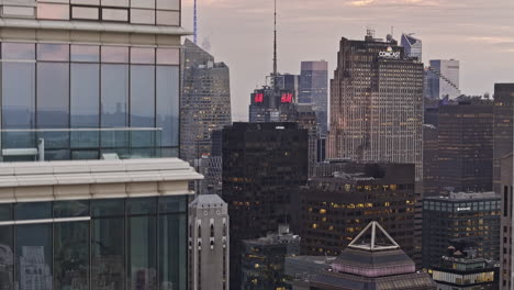 NYC-New-York-Aerial-v346-zoomed-drone-rising-fly-up-along-the-glass-skyscraper-of-Bloomberg-Tower-capturing-illuminated-cityscape-of-Midtown-Manhattan---Shot-with-Mavic-3-Pro-Cine---September-2023