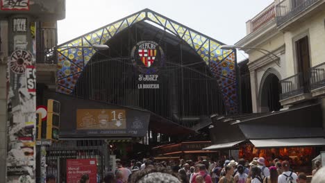 Malerischer-Eingang-Zum-Berühmten-Markt-La-Boqueria-In-Barcelona,-Fußgänger-Laufen-Durch-Die-Belebte-Marktstraße