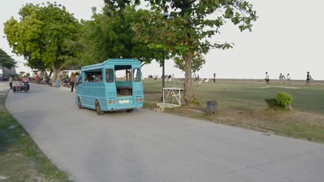 Coche-De-Transporte-Abierto-Azul-Conduciendo-Por-La-Carretera-A-Través-Del-Parque-En-Filipinas