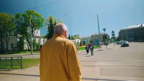 Un-Hombre-De-Amarillo-Se-Detiene-Esperando-Cruzar-La-Calle-En-Europa-Del-Este