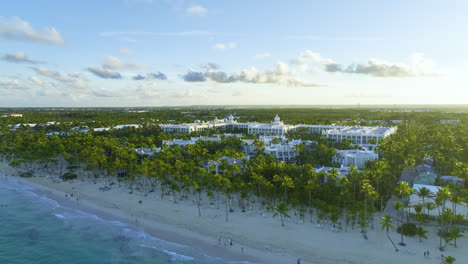Palm-Fringed-Beach-With-Exclusive-Luxury-Hotel-In-Punta-Cana,-Dominican-Republic