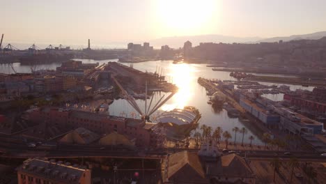 Genoa's-historic-center-at-sunset,-highlighting-the-bustling-port-and-colorful-buildings,-aerial-view