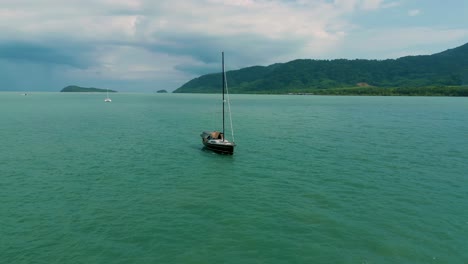 4K-Cinematic-nature-drone-footage-of-a-panoramic-aerial-view-of-boats-next-to-the-beautiful-beaches-and-mountains-on-the-island-of-Koh-Lanta-in-Krabi,-South-Thailand,-on-a-sunny-day
