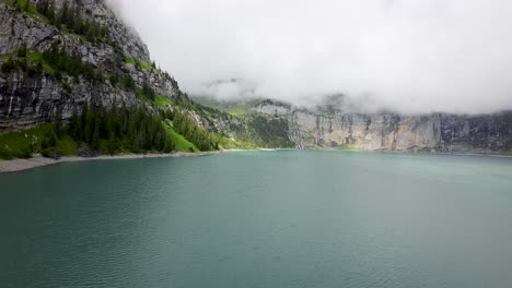 Drone-flight-towards-mountain-Landscape,-aerial-shot-over-a-blue-Oeschinen-lake,-Switzerland,-Europe